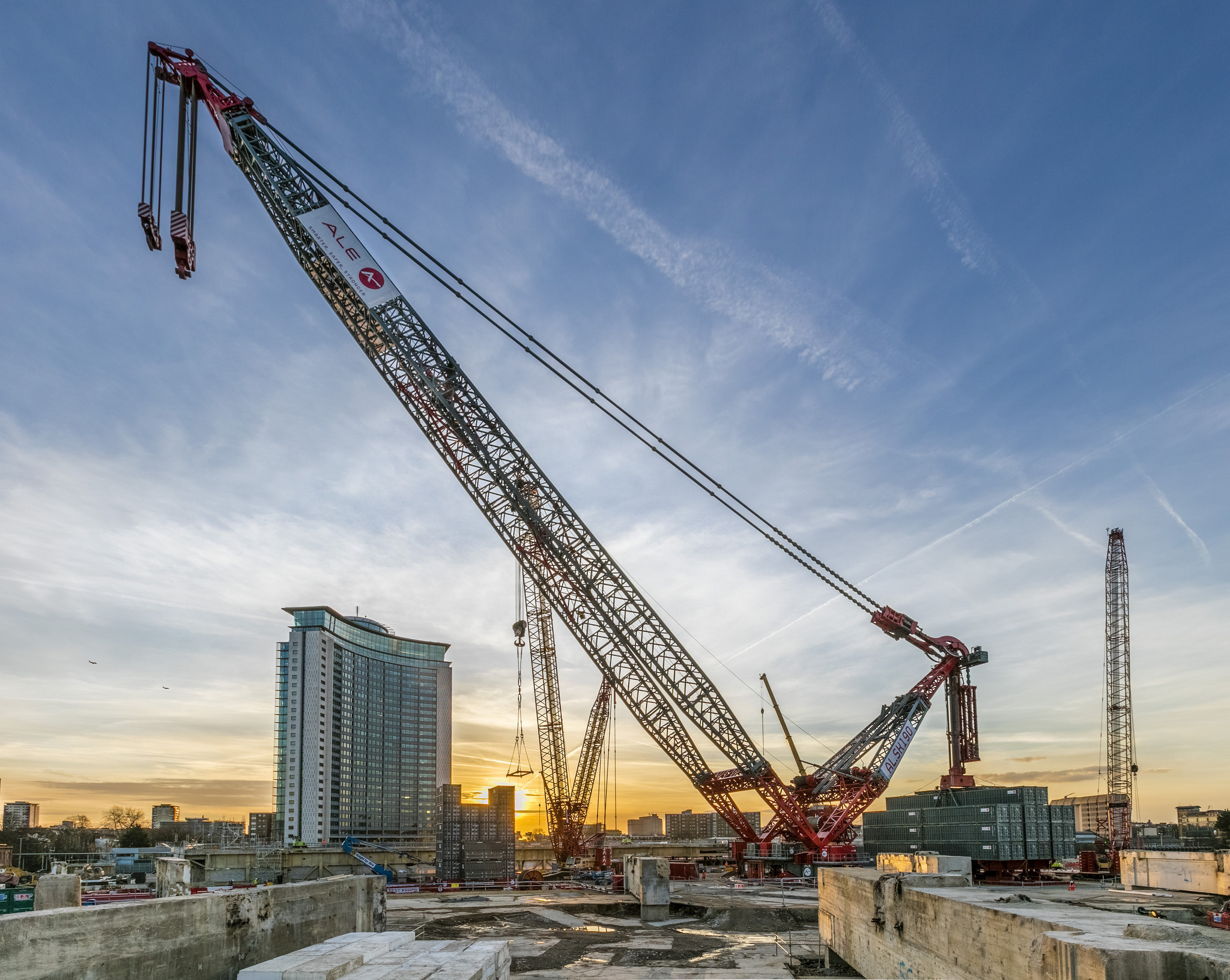 Complete overview of Highest Paying Crane Operator Specialties featuring certified crane operator executing lift plan with proper hand signals, ground crew coordination, and safety zone establishment per OSHA regulations