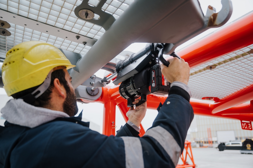 Crane operator performing boom pin inspection procedures during pre-shift inspection - critical skills tested on NCCCO written and practical exams for LAT and TSS certification