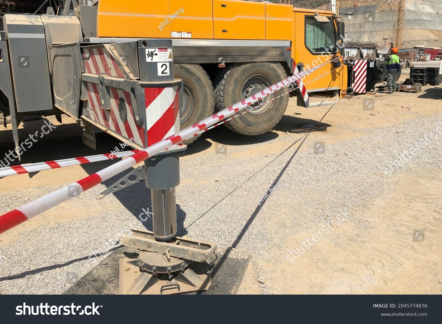 Complete overview of Outrigger Beam and Cylinder Inspection featuring certified crane operator executing lift plan with proper hand signals, ground crew coordination, and safety zone establishment per OSHA regulations