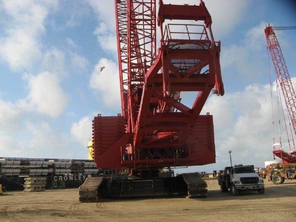 Complete overview of Manitowoc Crawler Crane Operation Guide featuring certified crane operator executing lift plan with proper hand signals, ground crew coordination, and safety zone establishment per OSHA regulations