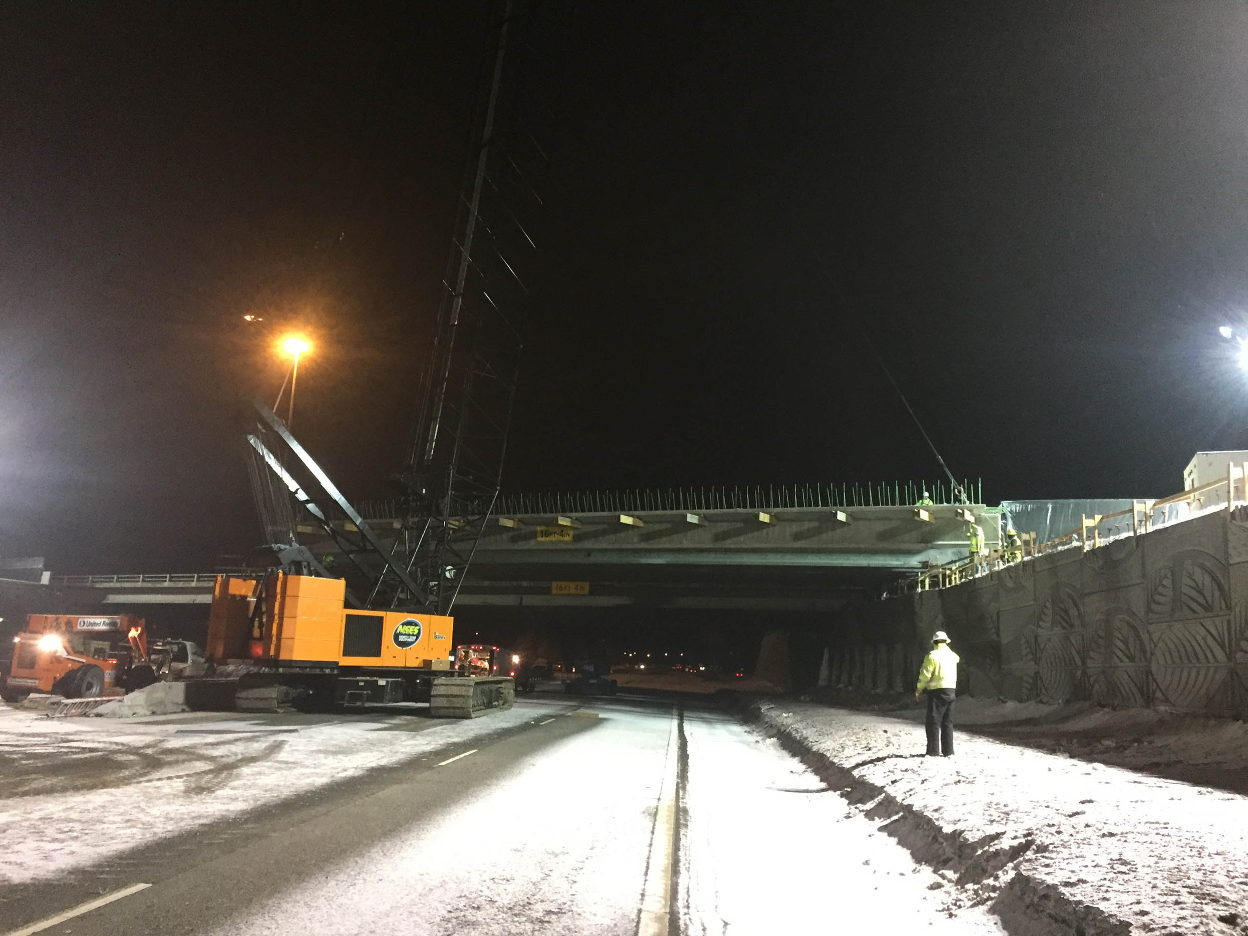 Professional crane operator demonstrating Night Crane Operations Safety techniques on an active construction site - essential knowledge for NCCCO certification exam preparation covering night crane operations safety protocols and operational procedures