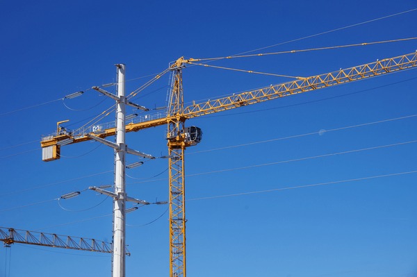Professional crane operator demonstrating Power Line Safety for Crane Operations techniques on an active construction site - essential knowledge for NCCCO certification exam preparation covering crane power lines safety protocols and operational procedures