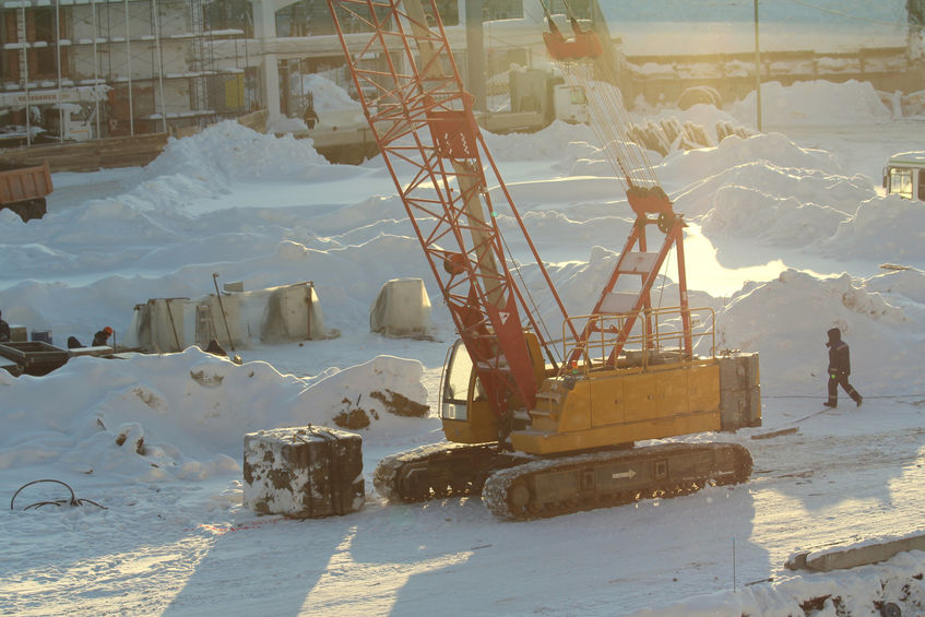 Complete overview of Cold Weather Crane Operation Safety featuring certified crane operator executing lift plan with proper hand signals, ground crew coordination, and safety zone establishment per OSHA regulations