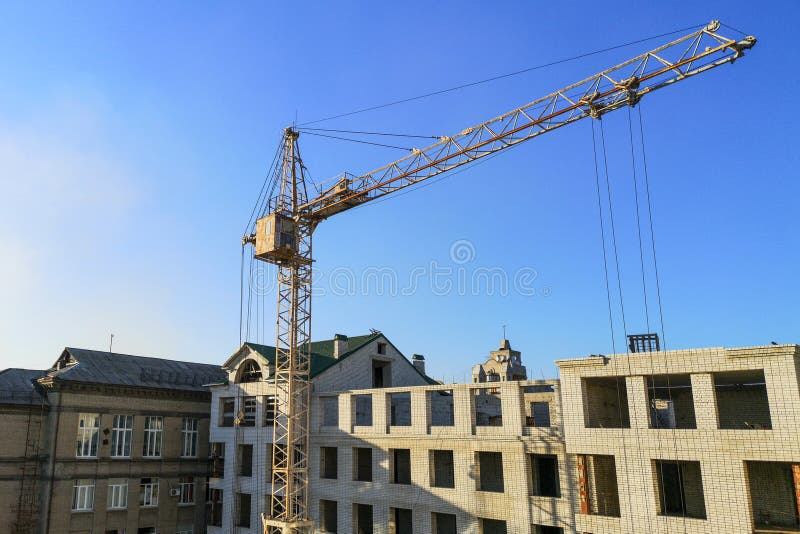 Professional crane operator demonstrating Crane Operations Near Existing Structures techniques on an active construction site - essential knowledge for NCCCO certification exam preparation covering crane near building safety protocols and operational procedures