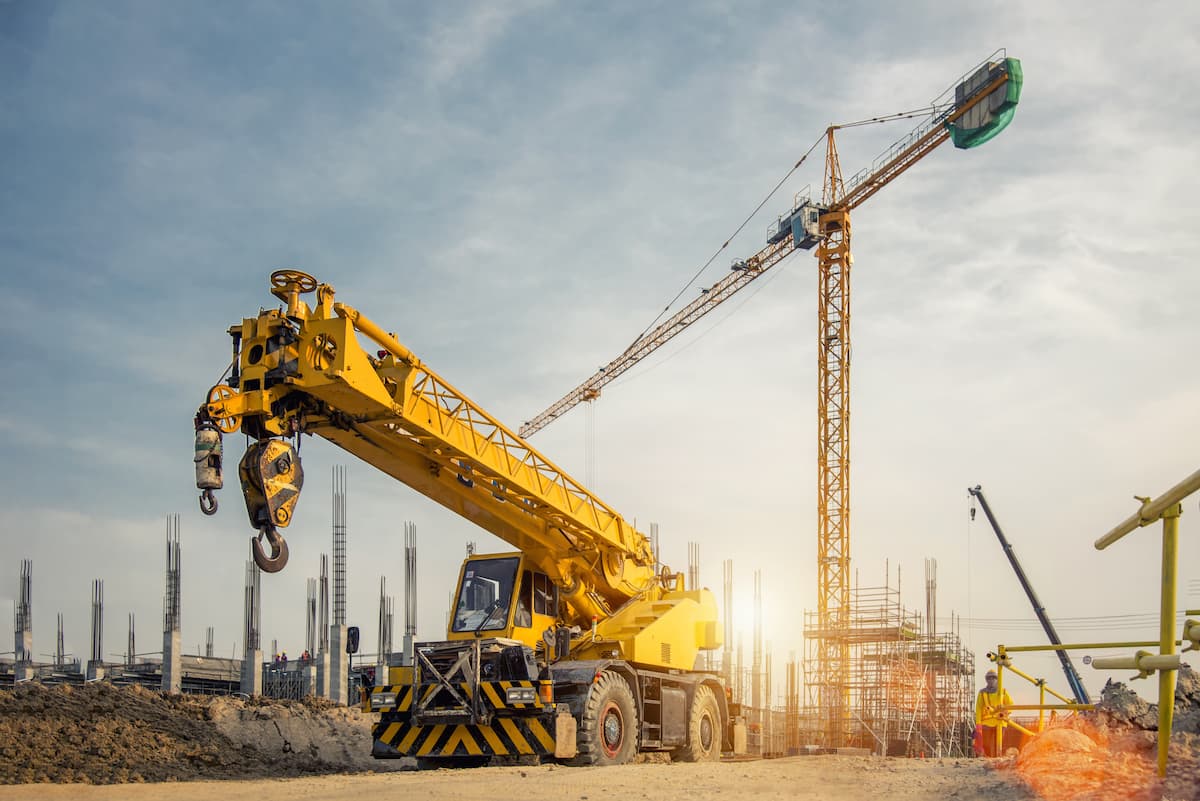 Professional crane operator demonstrating Crane Telematics and Fleet Management Systems techniques on an active construction site - essential knowledge for NCCCO certification exam preparation covering crane telematics safety protocols and operational procedures